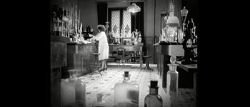 Movie still from “Talk to Her” (2002), directed by Pedro Almodóvar – An old photo of a woman working in a laboratory; Wide shot, High angle