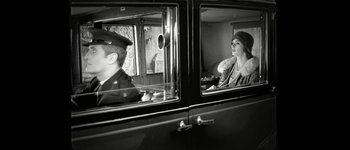 Movie still from “Talk to Her” (2002), directed by Pedro Almodóvar – A man and a woman sitting in the back of an old car; Medium shot, Low angle