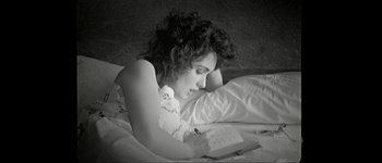 Movie still from “Talk to Her” (2002), directed by Pedro Almodóvar – A woman is laying in bed with a book; Close Up shot, High angle