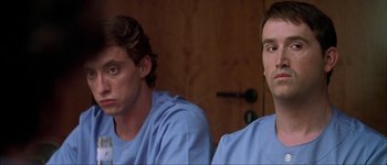 Movie still from “Talk to Her” (2002), directed by Pedro Almodóvar – A couple of men sitting next to each other in a room; Close Up shot, Low angle