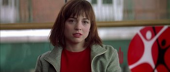 Movie still from “Talk to Her” (2002), directed by Pedro Almodóvar – A young woman with a red shirt is looking at the camera; Close Up shot, Over the shoulder angle