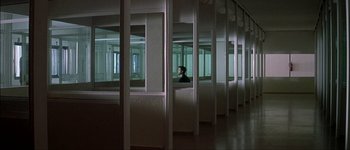 Movie still from “Talk to Her” (2002), directed by Pedro Almodóvar – A man sitting alone in a room with many windows; Extreme Wide shot, High angle