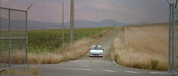 Movie still from “Talk to Her” (2002), directed by Pedro Almodóvar – A car is parked on the side of the road; Extreme Wide shot, High angle