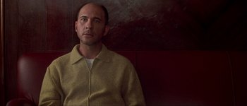 Movie still from “Talk to Her” (2002), directed by Pedro Almodóvar – A man sitting in front of a red wall; Close Up shot, Low angle
