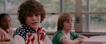 Movie still from “Talladega Nights: The Ballad of Ricky Bobby” (2006), directed by Adam McKay – Two young children sitting in a classroom together; Close Up shot, Over the shoulder angle