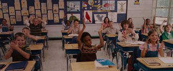 Movie still from “Talladega Nights: The Ballad of Ricky Bobby” (2006), directed by Adam McKay – A group of children sitting at their desks raising their hands; Medium shot, High angle