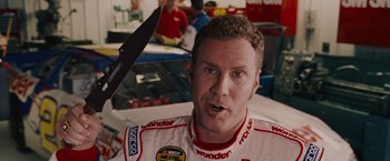 Movie still from “Talladega Nights: The Ballad of Ricky Bobby” (2006), directed by Adam McKay – A person in a race car; Close Up shot, High angle