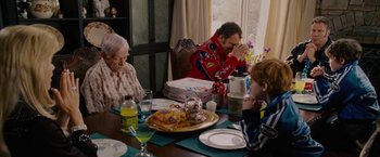 Movie still from “Talladega Nights: The Ballad of Ricky Bobby” (2006), directed by Adam McKay – A group of people sitting at a table with food on it; Medium shot, High angle