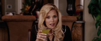 Movie still from “Talladega Nights: The Ballad of Ricky Bobby” (2006), directed by Adam McKay – A woman holding up a drink in her right hand; Close Up shot, Over the shoulder angle