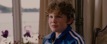 Movie still from “Talladega Nights: The Ballad of Ricky Bobby” (2006), directed by Adam McKay – A young boy in a blue and white striped jacket; Close Up shot, Over the shoulder angle