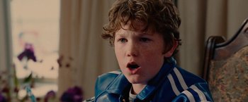 Movie still from “Talladega Nights: The Ballad of Ricky Bobby” (2006), directed by Adam McKay – A young boy with a surprised look on his face; Close Up shot, Over the shoulder angle
