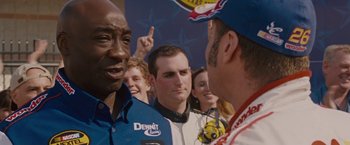 Movie still from “Talladega Nights: The Ballad of Ricky Bobby” (2006), directed by Adam McKay – A group of men standing next to each other in a crowd; Close Up shot, Over the shoulder angle