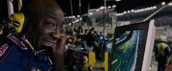 Movie still from “Talladega Nights: The Ballad of Ricky Bobby” (2006), directed by Adam McKay – A man holding his hand up to his face while taking a picture of himself; Close Up shot, Over the shoulder angle