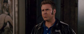 Movie still from “Talladega Nights: The Ballad of Ricky Bobby” (2006), directed by Adam McKay – A person wearing a leather jacket; Close Up shot, Over the shoulder angle