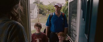 Movie still from “Talladega Nights: The Ballad of Ricky Bobby” (2006), directed by Adam McKay – A man and two young boys standing on the steps of a house; Medium shot, Over the shoulder angle