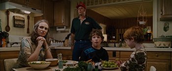 Movie still from “Talladega Nights: The Ballad of Ricky Bobby” (2006), directed by Adam McKay – A man and a boy sitting at a table with a bowl of grapes; Medium shot, Over the shoulder angle