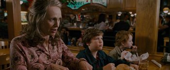 Movie still from “Talladega Nights: The Ballad of Ricky Bobby” (2006), directed by Adam McKay – A woman and a boy sitting at a table in a restaurant; Medium shot, Over the shoulder angle
