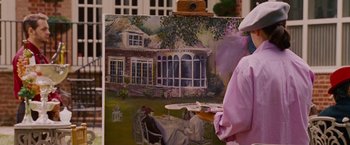 Movie still from “Talladega Nights: The Ballad of Ricky Bobby” (2006), directed by Adam McKay – A person holding a painting of a house; Medium shot, Over the shoulder angle