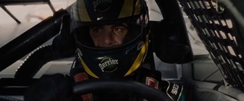 Movie still from “Talladega Nights: The Ballad of Ricky Bobby” (2006), directed by Adam McKay – A man wearing a racing helmet sitting in a race car; Close Up shot, High angle