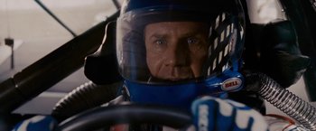 Movie still from “Talladega Nights: The Ballad of Ricky Bobby” (2006), directed by Adam McKay – A person wearing a helmet in a race car; Close Up shot, Over the shoulder angle