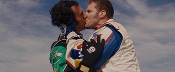 Movie still from “Talladega Nights: The Ballad of Ricky Bobby” (2006), directed by Adam McKay – A couple of men kissing each other on the lips; Close Up shot, Over the shoulder angle