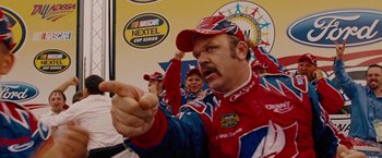 Movie still from “Talladega Nights: The Ballad of Ricky Bobby” (2006), directed by Adam McKay – A group of men in racing outfits pointing at something; Medium shot, Low angle