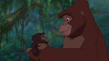 Movie still from “Tarzan” (1999), directed by Kevin Lima – An adult gorilla holding a baby gorilla in front of trees; Medium shot, Low angle