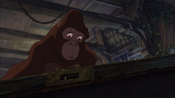 Movie still from “Tarzan” (1999), directed by Kevin Lima – A gorilla is standing in front of a wooden structure; Medium shot, Low angle