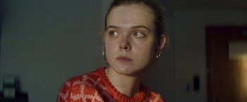 Movie still from “Teen Spirit” (2018), directed by Max Minghella – A woman with a red sweater looking to her left; Close Up shot, High angle