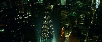 Movie still from “Teenage Mutant Ninja Turtles: Out of the Shadows” (2016), directed by Dave Green – A very tall building lit up at night in a city; Extreme Wide shot, Overhead angle