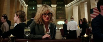 Movie still from “Teenage Mutant Ninja Turtles: Out of the Shadows” (2016), directed by Dave Green – A woman sitting at a table in front of a group of people; Medium shot, Over the shoulder angle