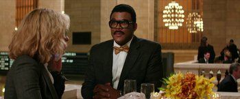 Movie still from “Teenage Mutant Ninja Turtles: Out of the Shadows” (2016), directed by Dave Green – A man sitting at a dinner table wearing a suit and bow tie; Medium shot, Over the shoulder angle