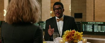 Movie still from “Teenage Mutant Ninja Turtles: Out of the Shadows” (2016), directed by Dave Green – A man in a suit and bow tie talking to a woman in a suit; Medium shot, Over the shoulder angle