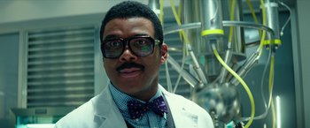 Movie still from “Teenage Mutant Ninja Turtles: Out of the Shadows” (2016), directed by Dave Green – A man in a white lab coat and a bow tie; Close Up shot, Low angle