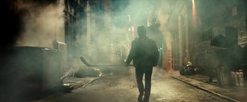 Movie still from “Teenage Mutant Ninja Turtles: Out of the Shadows” (2016), directed by Dave Green – A man walking down a street holding a hockey stick; Wide shot, Low angle