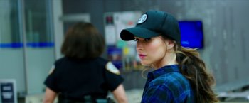 Movie still from “Teenage Mutant Ninja Turtles: Out of the Shadows” (2016), directed by Dave Green – A woman wearing a baseball cap and plaid shirt; Close Up shot, Over the shoulder angle