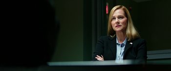 Movie still from “Teenage Mutant Ninja Turtles: Out of the Shadows” (2016), directed by Dave Green – A woman sitting at a table with her arms crossed; Close Up shot, Over the shoulder angle