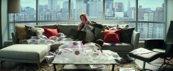 Movie still from “Teenage Mutant Ninja Turtles: Out of the Shadows” (2016), directed by Dave Green – A woman sitting on a couch in front of a coffee table; Medium shot, High angle