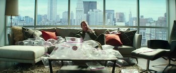 Movie still from “Teenage Mutant Ninja Turtles: Out of the Shadows” (2016), directed by Dave Green – A man sitting on top of a couch in a living room; Medium shot, High angle