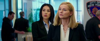 Movie still from “Teenage Mutant Ninja Turtles: Out of the Shadows” (2016), directed by Dave Green – Two women in business suits standing next to each other in an office setting; Medium shot, Low angle
