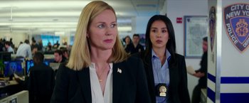 Movie still from “Teenage Mutant Ninja Turtles: Out of the Shadows” (2016), directed by Dave Green – Two women in suits and necklaces in an office building; Medium shot, Over the shoulder angle