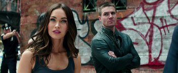 Movie still from “Teenage Mutant Ninja Turtles: Out of the Shadows” (2016), directed by Dave Green – A man and a woman standing next to each other in front of a wall; Close Up shot, Over the shoulder angle