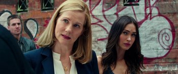 Movie still from “Teenage Mutant Ninja Turtles: Out of the Shadows” (2016), directed by Dave Green – Two women standing next to each other in front of a wall; Close Up shot, Over the shoulder angle