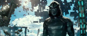 Movie still from “Teenage Mutant Ninja Turtles: Out of the Shadows” (2016), directed by Dave Green – A man in a black leather suit standing in front of a building; Medium shot, Low angle