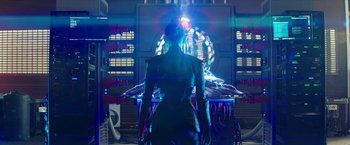 Movie still from “Teenage Mutant Ninja Turtles: Out of the Shadows” (2016), directed by Dave Green – A woman standing in front of a table with lights on it; Medium shot, Over the shoulder angle