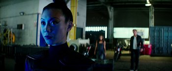 Movie still from “Teenage Mutant Ninja Turtles: Out of the Shadows” (2016), directed by Dave Green – A woman standing in front of motorcycles in a garage; Close Up shot, Over the shoulder angle