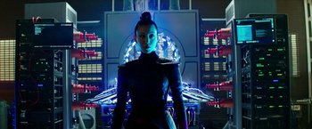 Movie still from “Teenage Mutant Ninja Turtles: Out of the Shadows” (2016), directed by Dave Green – A woman standing in front of a building with lights on it; Medium shot, Low angle