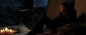 Movie still from “Terminator 3: Rise of the Machines” (2003), directed by Jonathan Mostow – A man sitting on the ground in the dark; Wide shot, High angle