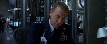 Movie still from “Terminator 3: Rise of the Machines” (2003), directed by Jonathan Mostow – A person wearing a uniform; Close Up shot, Over the shoulder angle