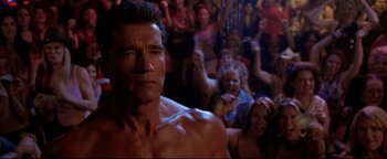 Movie still from “Terminator 3: Rise of the Machines” (2003), directed by Jonathan Mostow – A shirtless man in front of a group of people; Close Up shot, Low angle